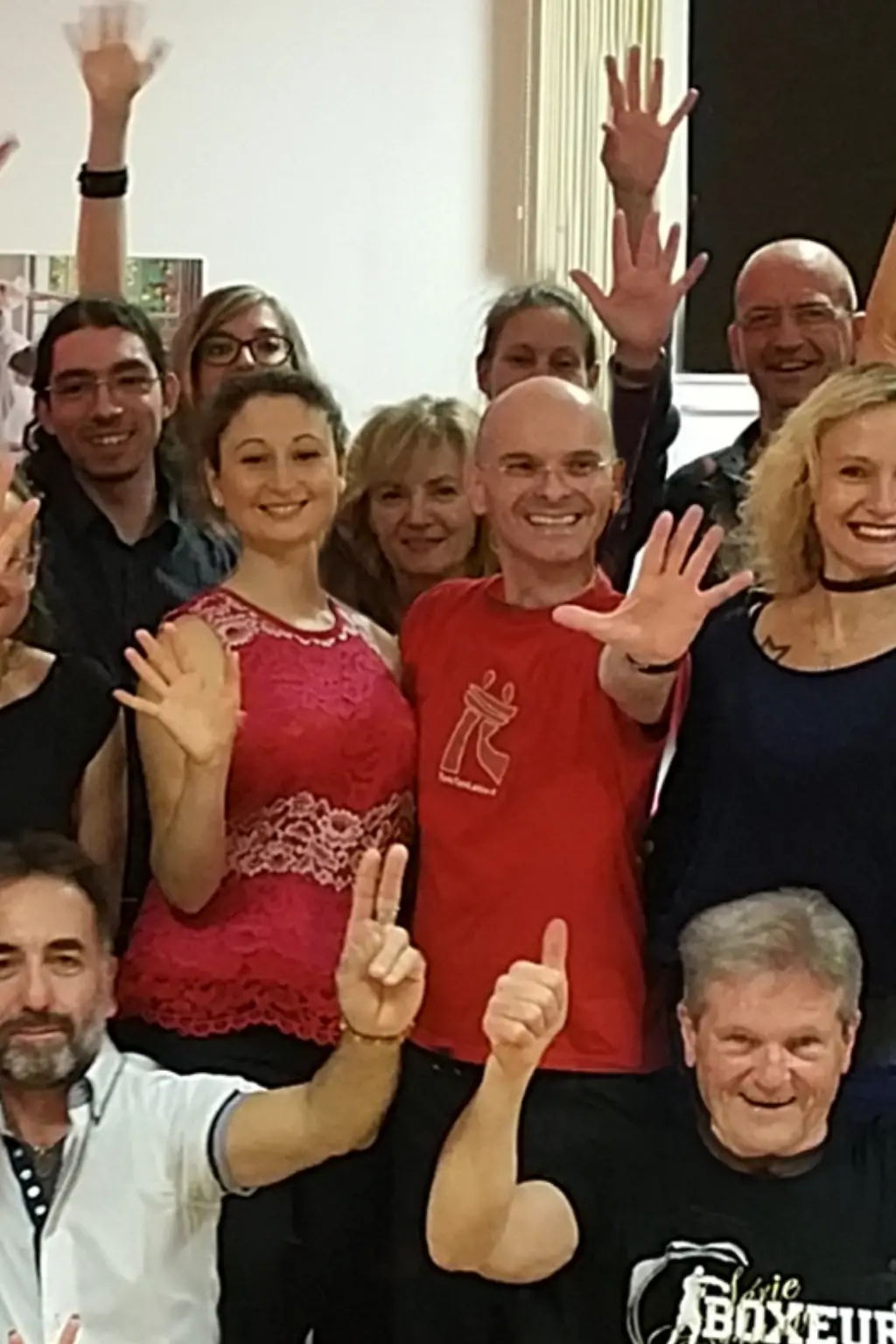 Foto di gruppo di fine stage di ballo: insegnanti di danza al centro circondati dagli allievi, tutti sorridenti e con le mani alzate, a rappresentare corsi di ballo, formazione dal vivo, condivisione, energia di gruppo ed esperienza didattica maturata attraverso workshop e stage.